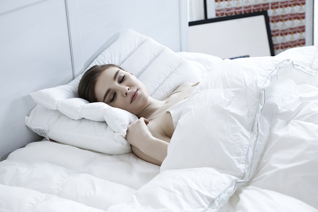 Žena s hnedými vlasmi spí v posteli.jpg