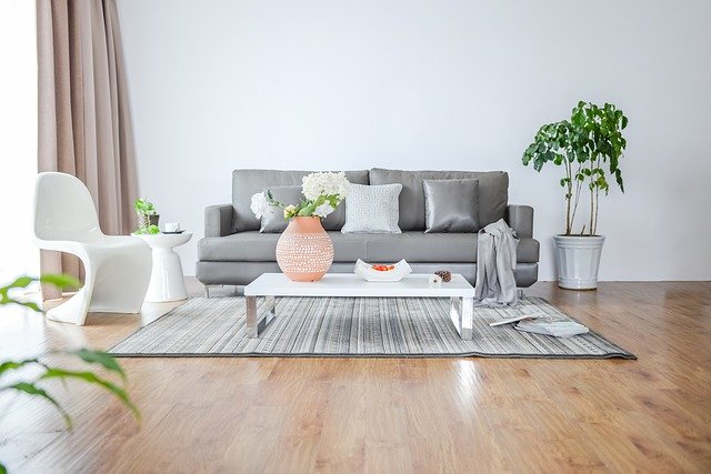 Moderne zariadená obývacia izba s hnedou podlahou a sivým gaučom.jpg